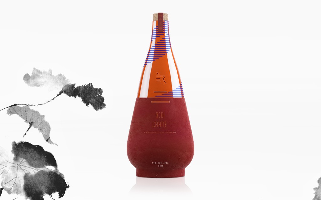 A tall red vessel beside a monochrome ink painting of lotus leaves